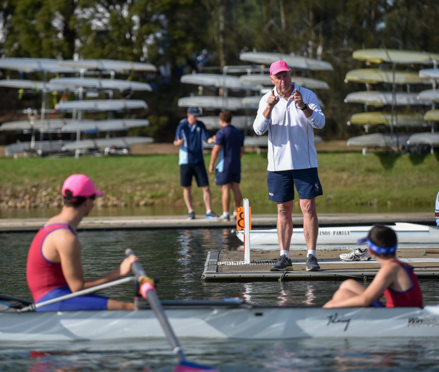 Rowing coach instructing boys that are in water
