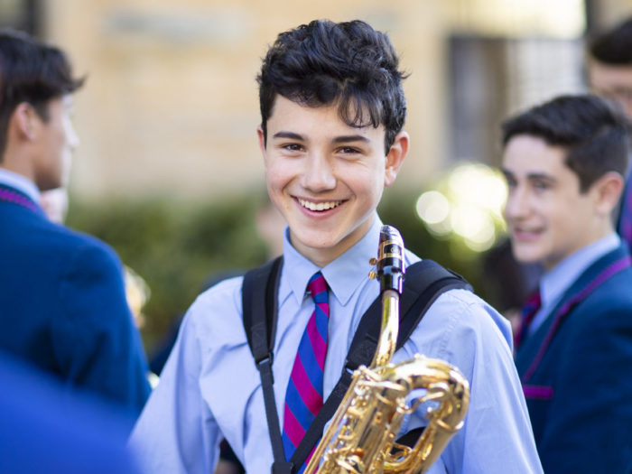 boy holding musical instrument and smiling