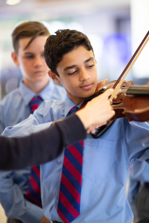 boy leaning to play violin