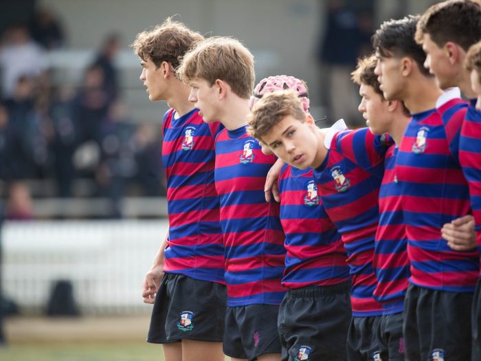 boys standing in row on rugby field